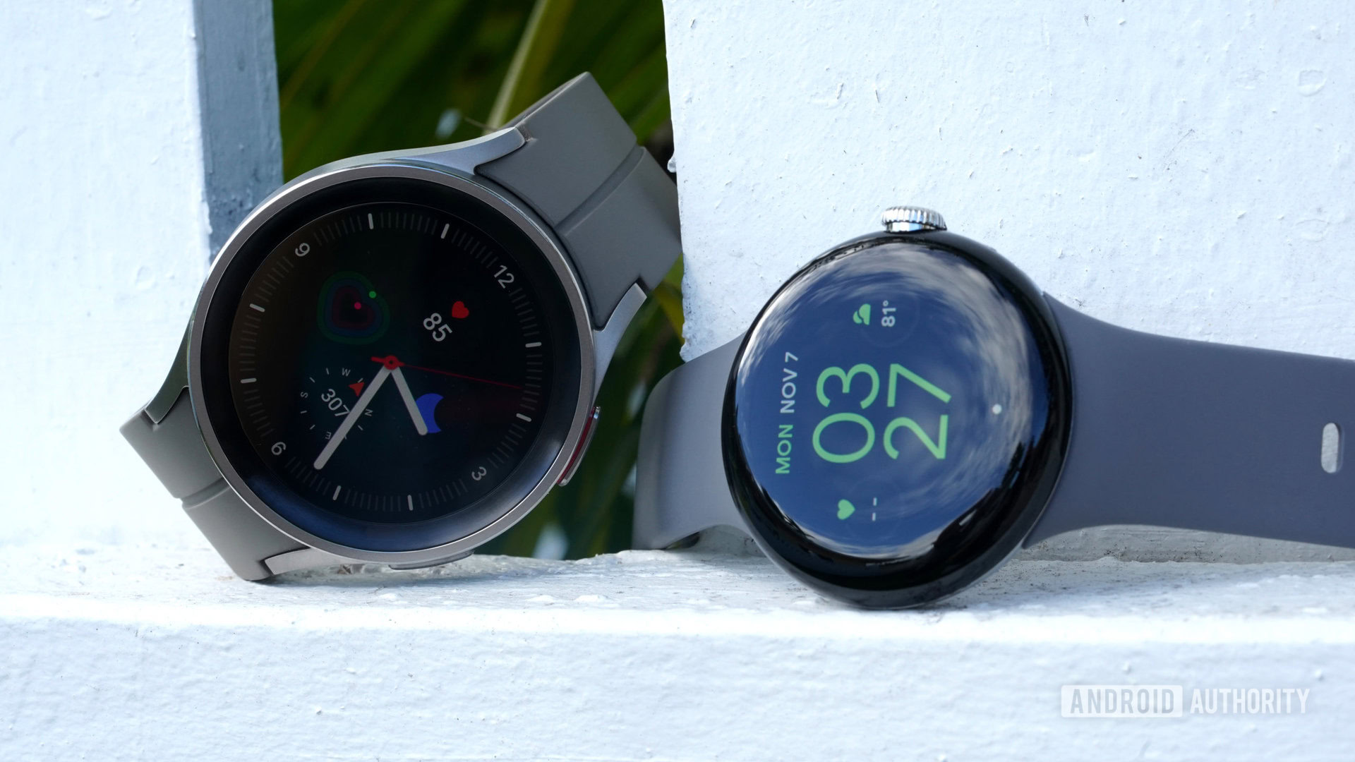 Google Pixel Watch vs Galaxy Watch 5 Series A Google Pixel Watch rests alongside a Galaxy Watch 5 pro.