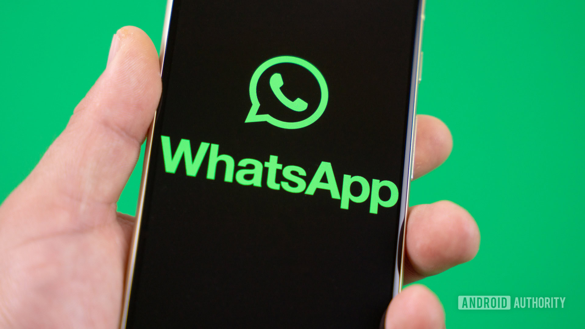 Holding smartphone with WhatsApp logo on the screen Stock photo Holding smartphone with WhatsApp logo on the screen Stock photo