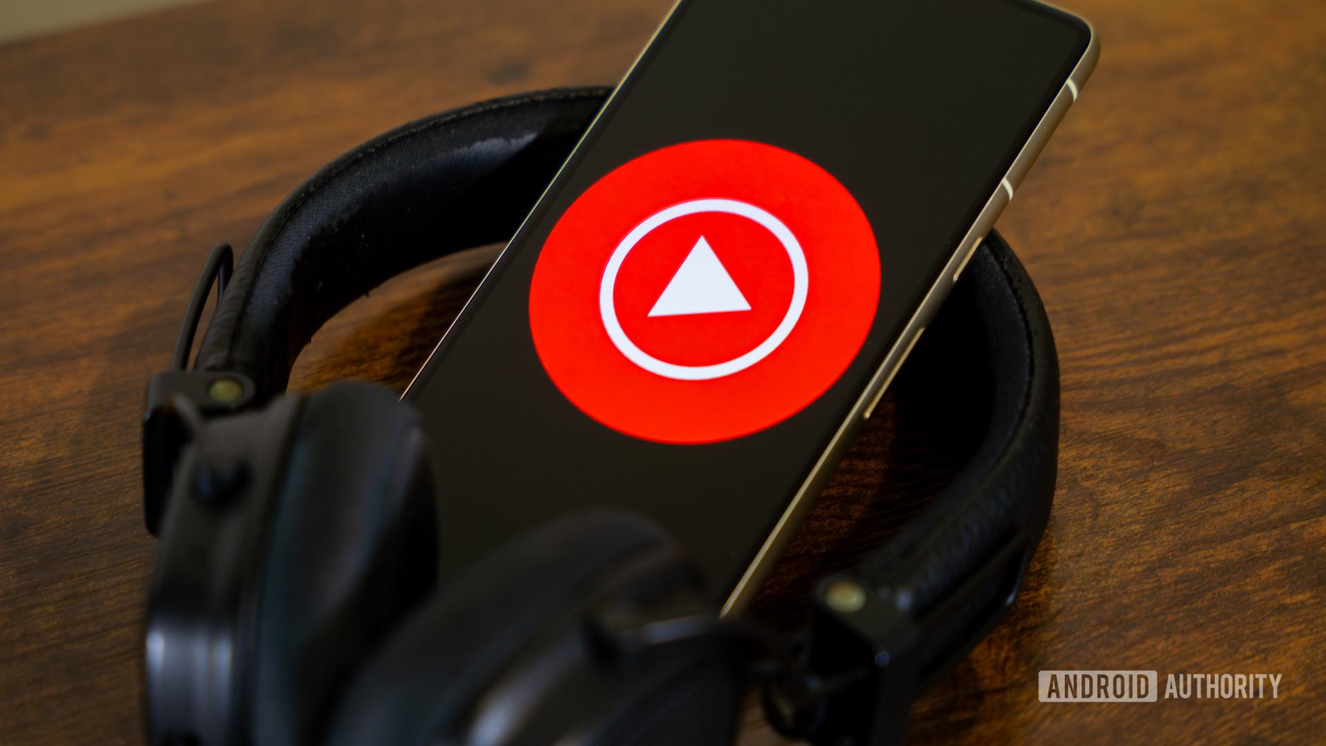 YouTube Music logo on smartphone with headphones YouTube Music logo on smartphone with headphones