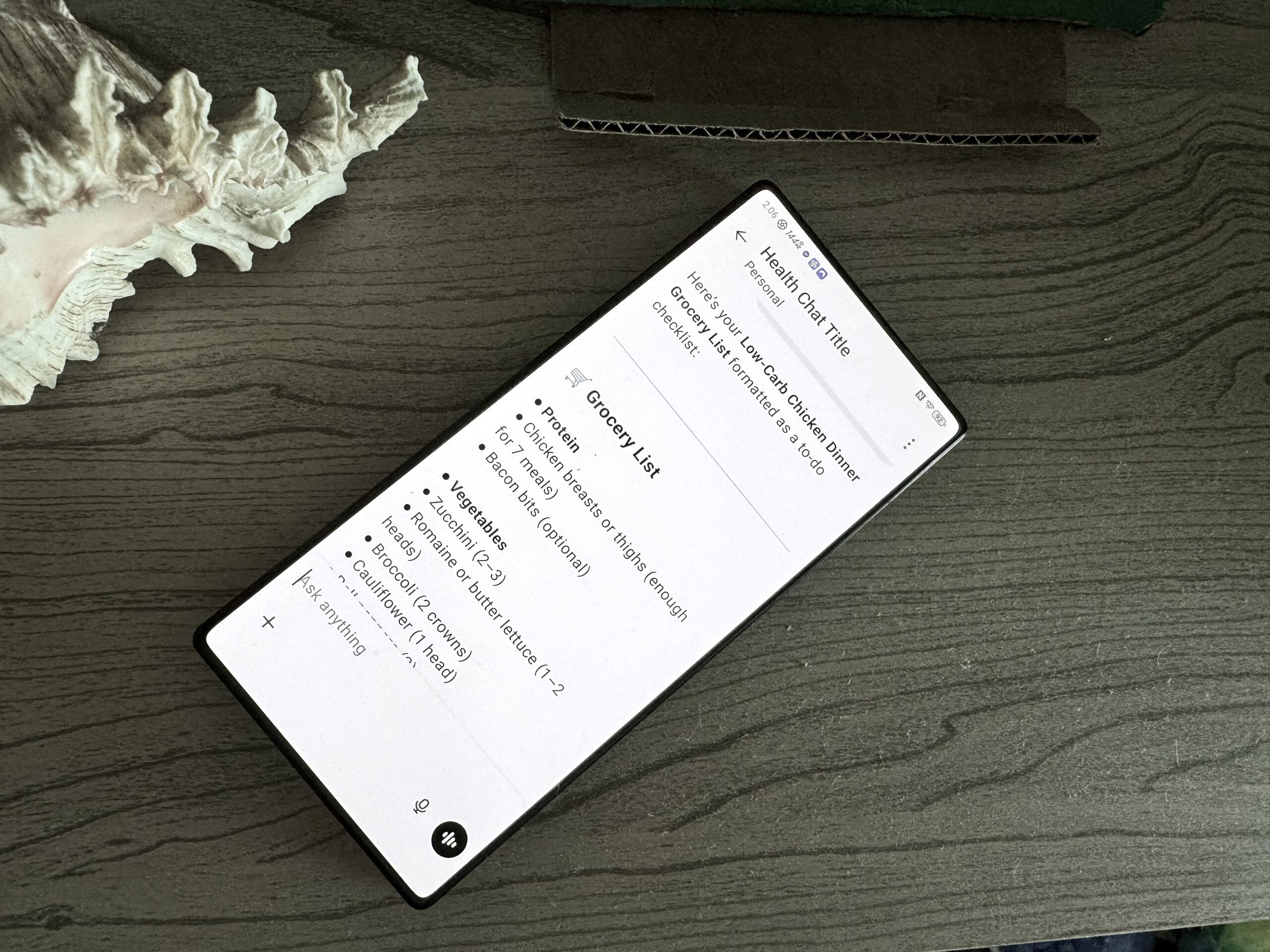 ChatGPT grocery list ChatGPT with a grocery list on a wooden surface next to a seashell.